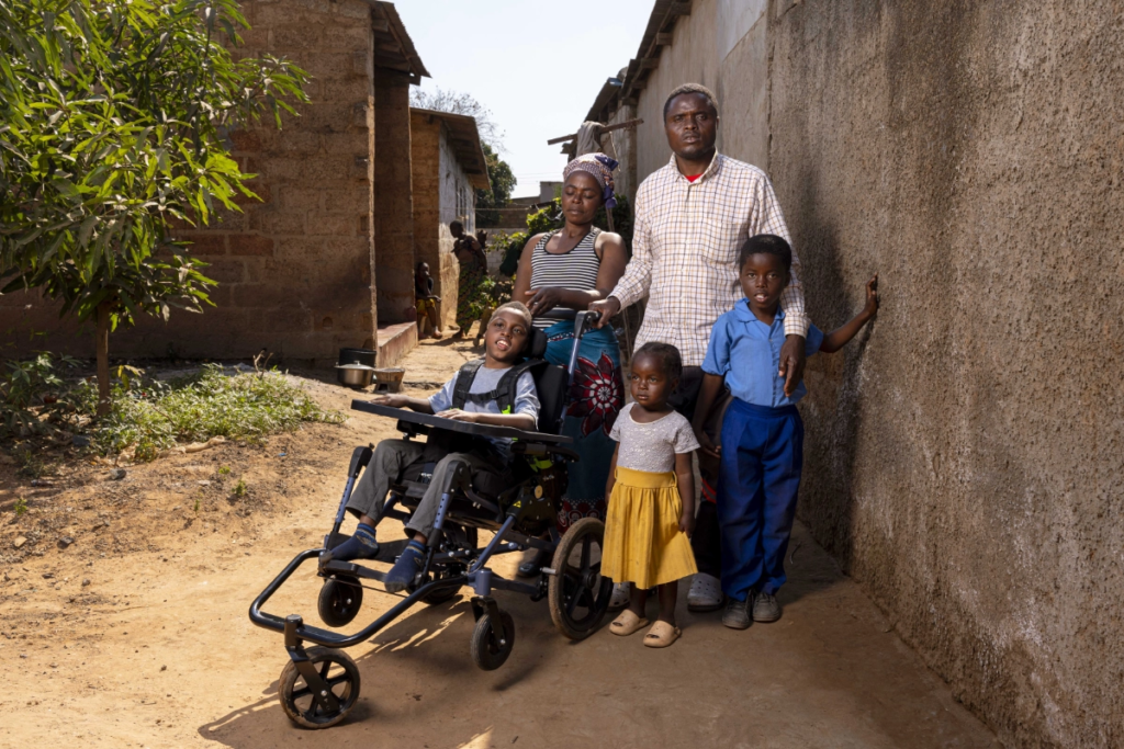 Chisomo in his new wheelchair, next to his siblings and parents