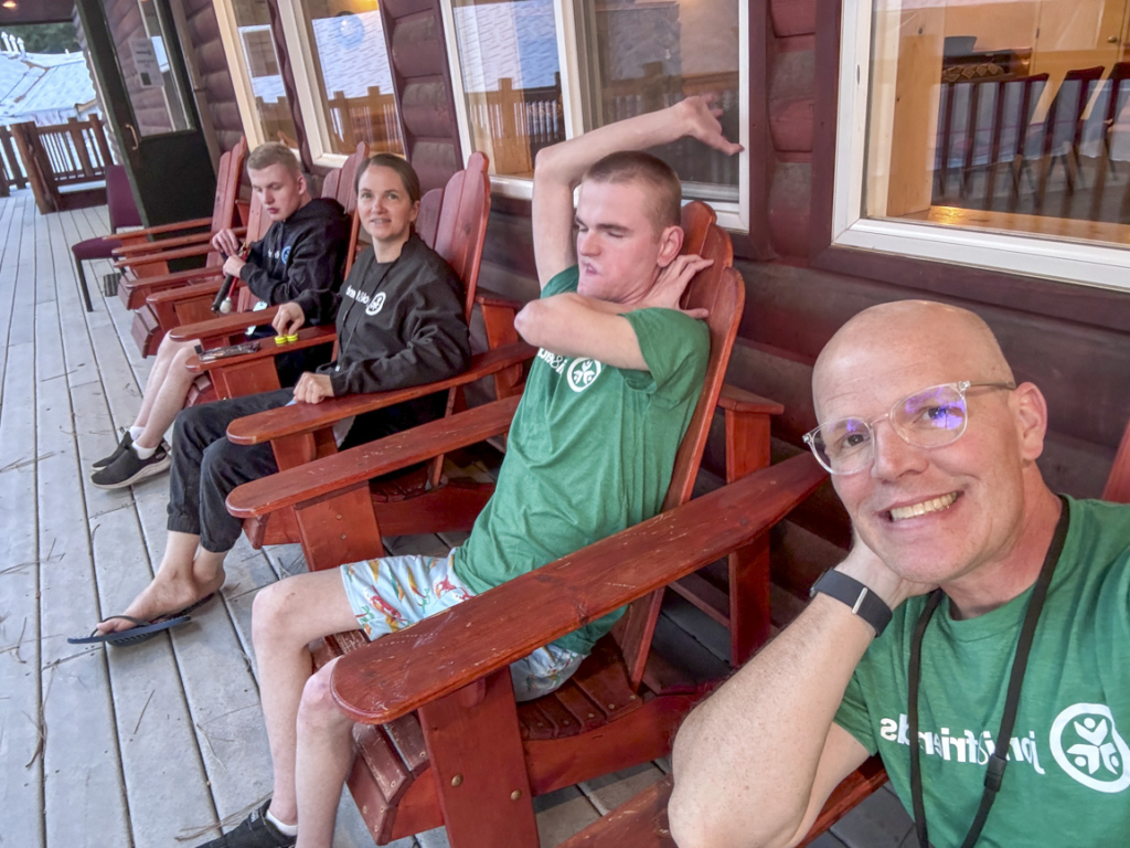 Jared, Dino, Laura, and Tyson Graham sitting together and enjoying a relaxing moment. They are dressed in outfits featuring the Joni & Friends logo.