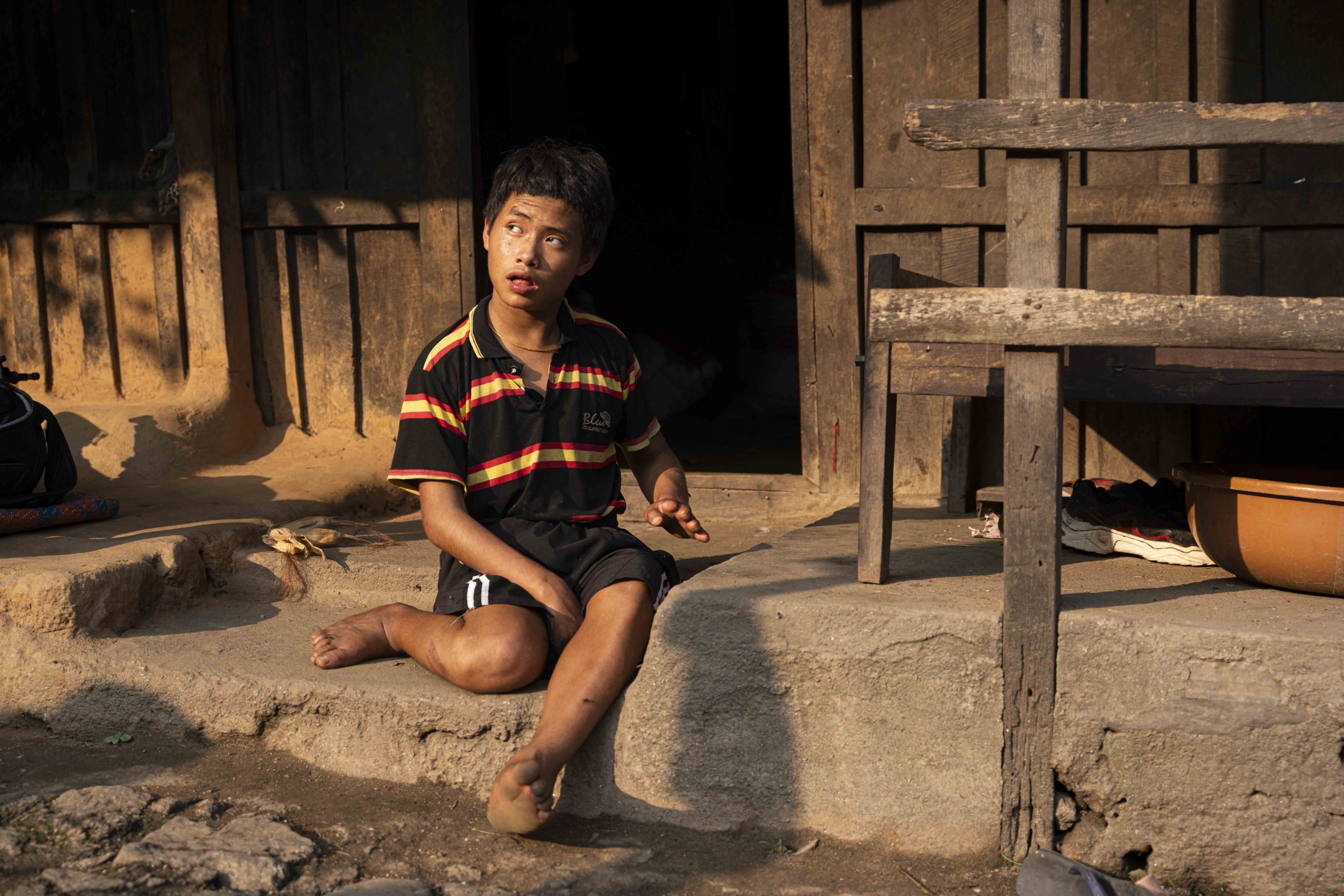 Surya sitting on a cemented step in front of their house.