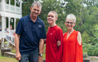 Will, Noah, and JJ smiling brightly and posing for the camera outdoors, enjoying their time at the Family Retreat.