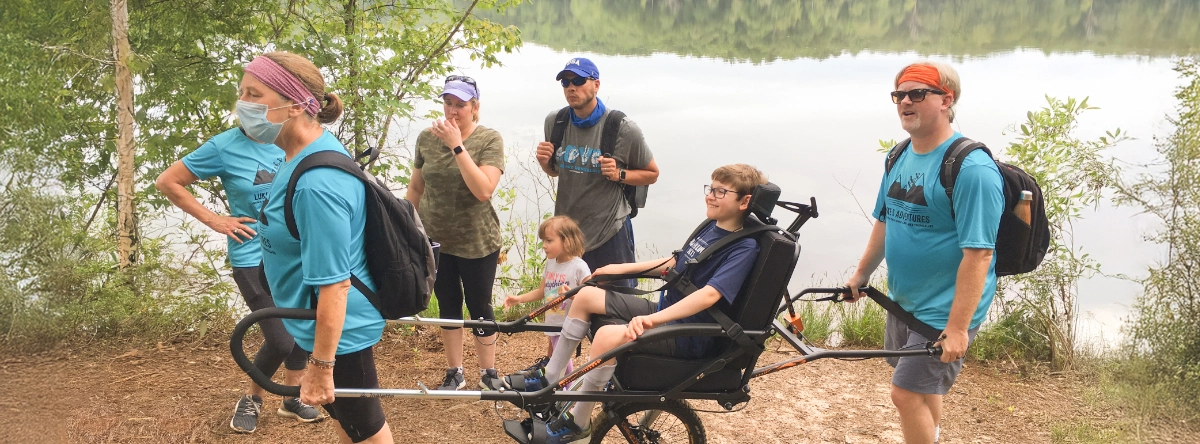 People hiking on a trail near a lake