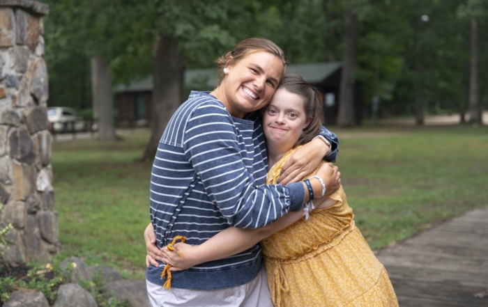 Ellie and Molly hugging each other tightly and smiling at the camera.