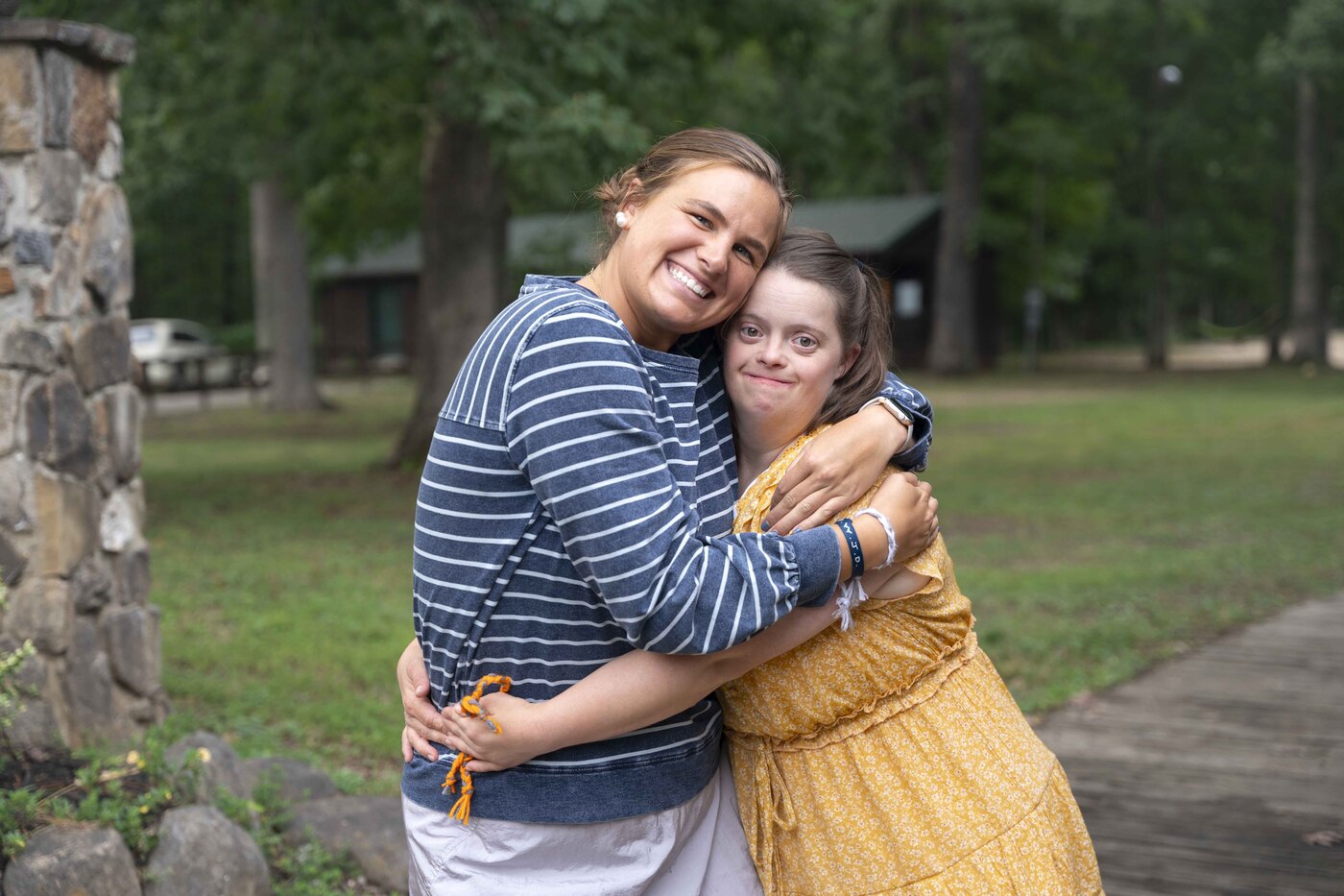 Ellie and Molly hugging each other tightly and smiling at the camera.