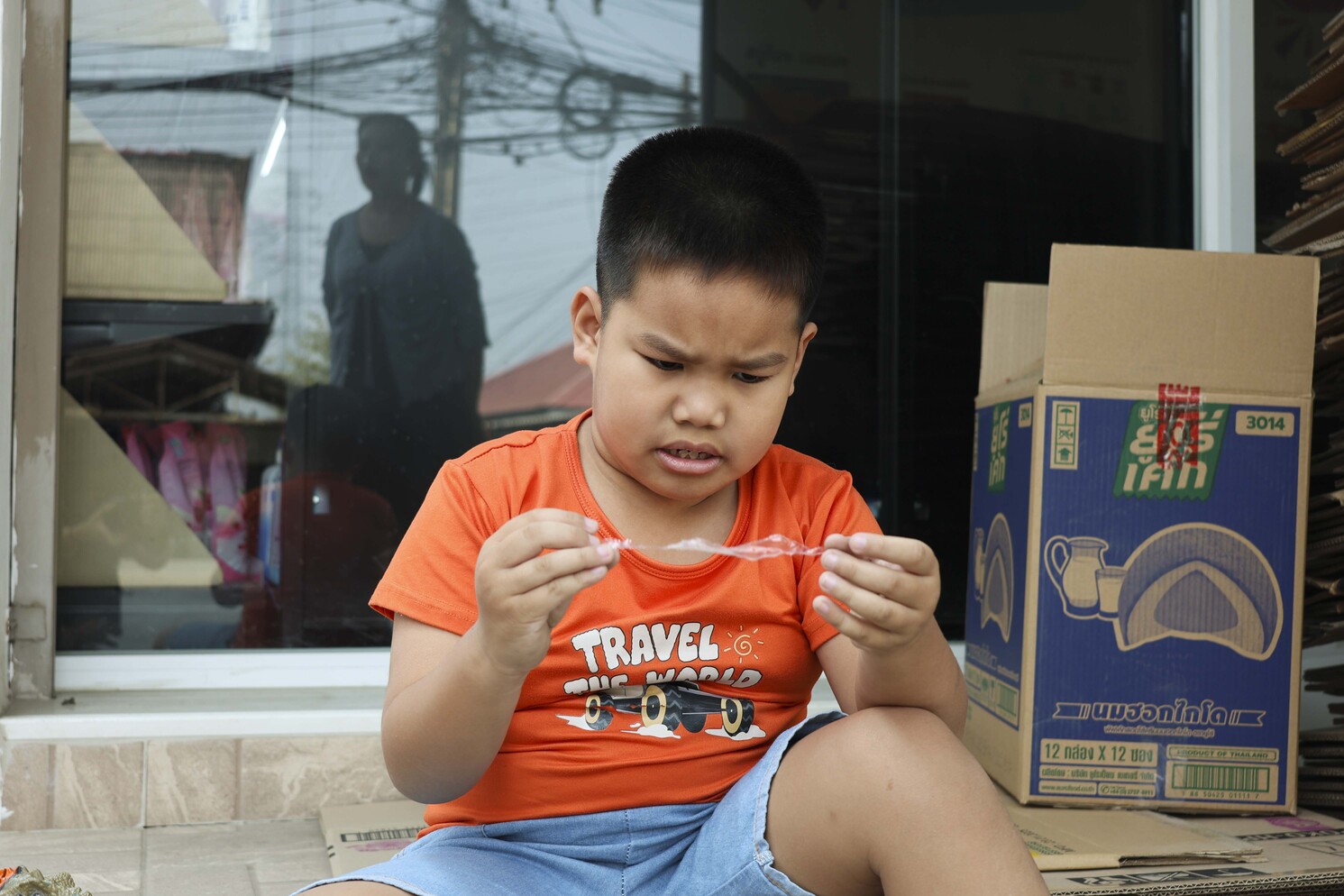 Praram sitting and looking intently at a plastic.