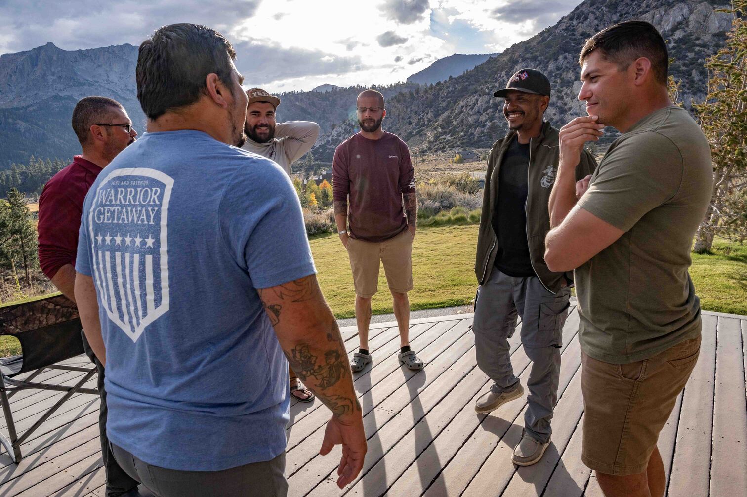 JB smiling with other veterans in a circle during Warrior Getaway, with beautiful mountains in the background.