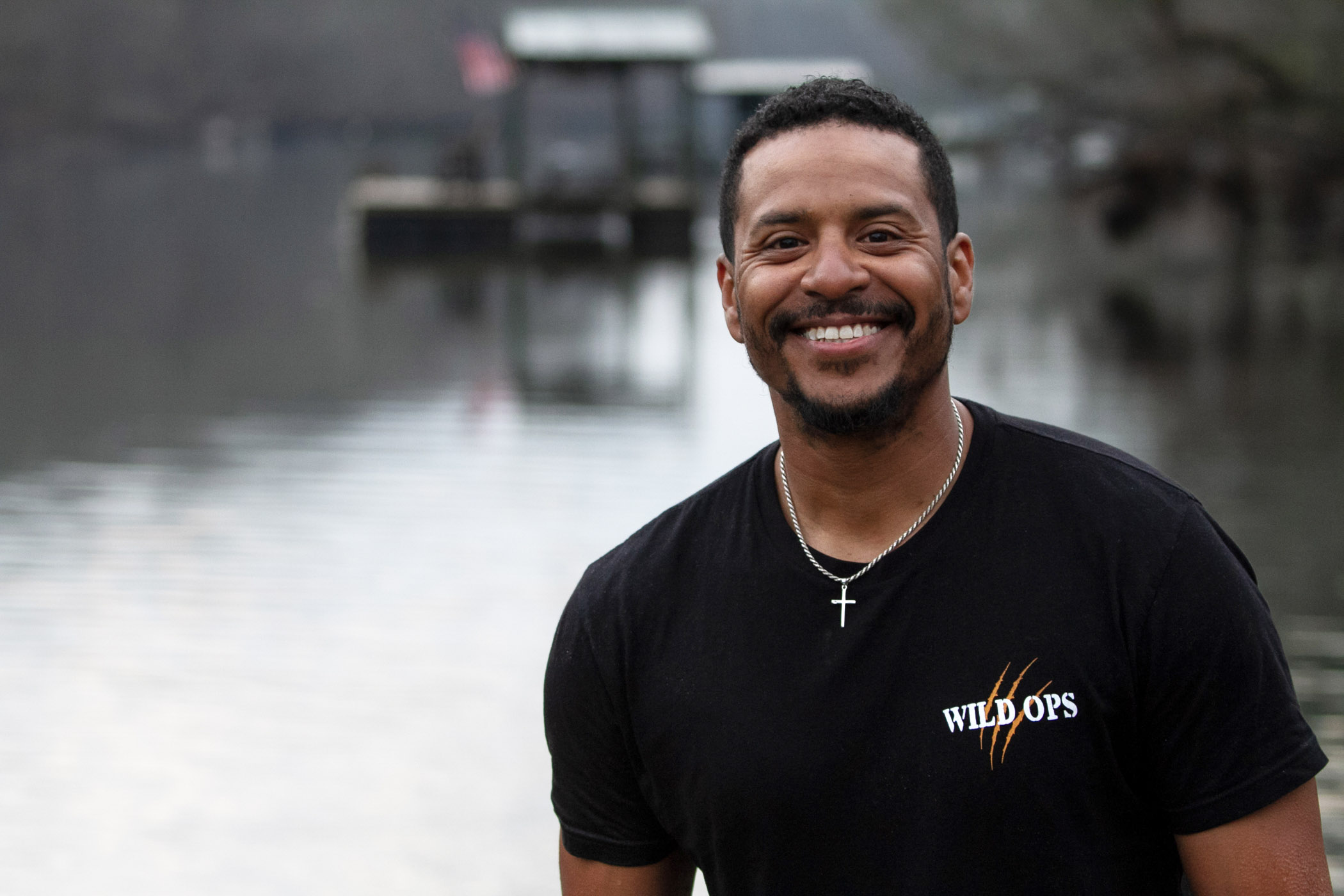 JB Basaldua smiling at the camera with a river in the background.
