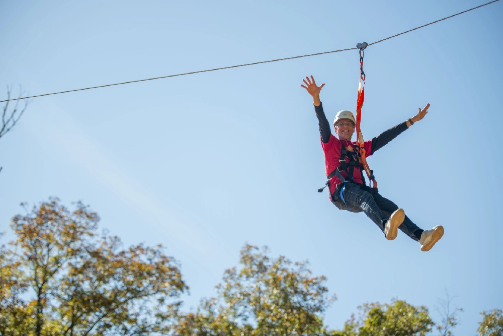 A man on a zip line at Family Retreat