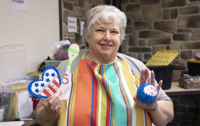 Deb Butcher holding her art crafts.
