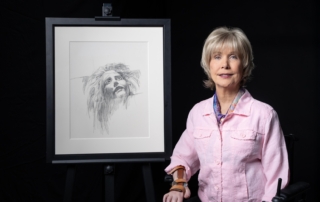 Joni next to her artwork titled "Face of Anguish"