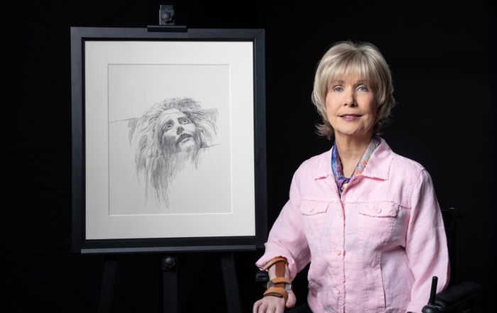 Joni next to her artwork titled "Face of Anguish"