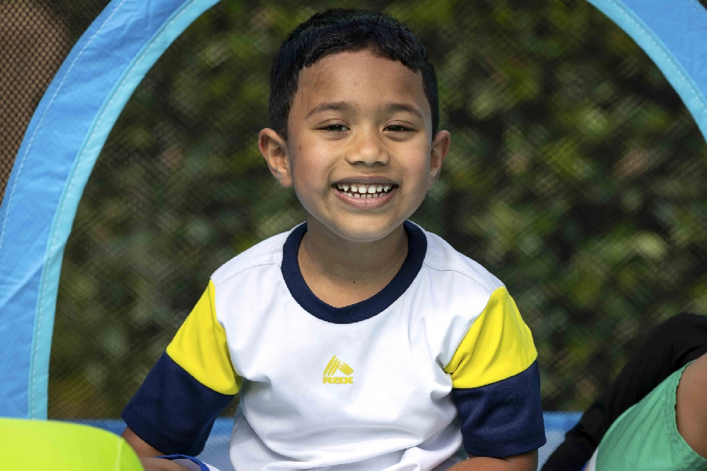A boy smiling for a photo at Family Retreat