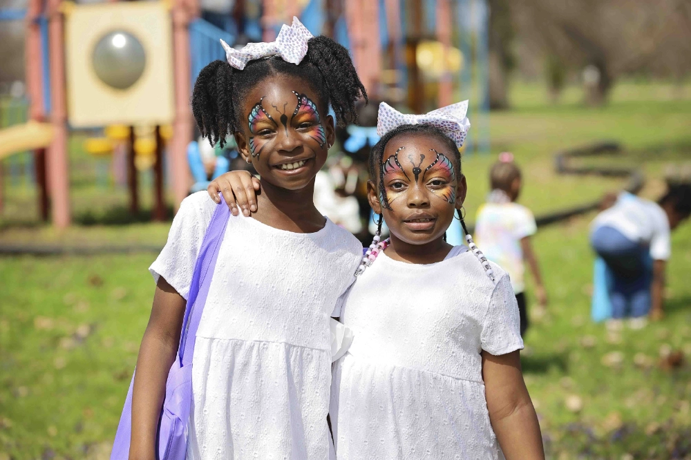 Two girls pose for a photo with butterfly painted faces