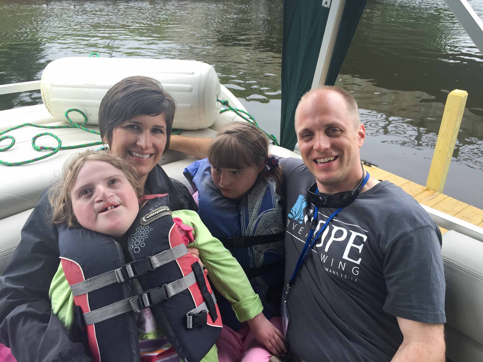 Paul and Kathy with their daughters, Katelyn and Madelyn, in a boat, enjoying their time at Family Retreat.
