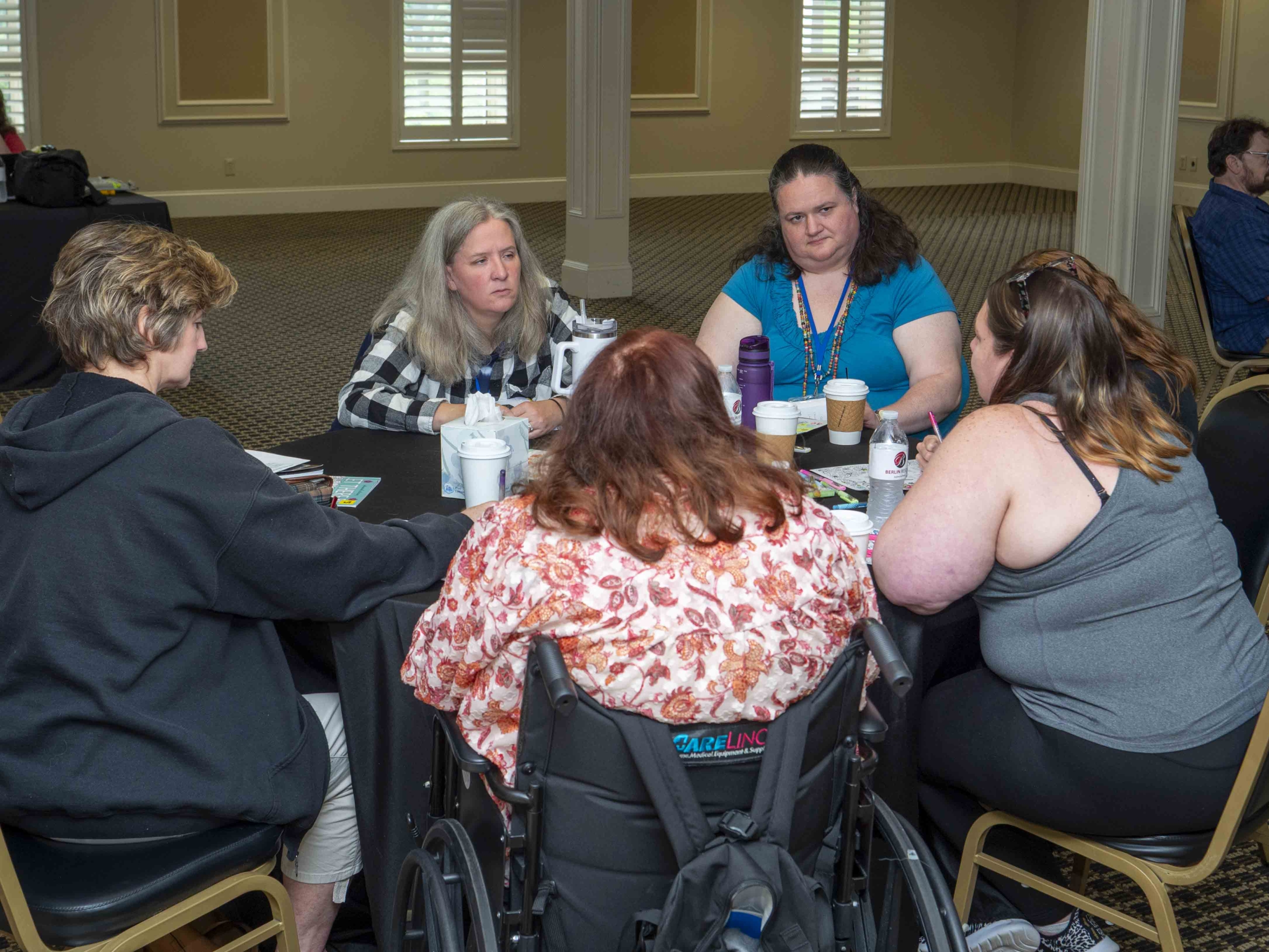 Rachel sitting at a table in a circle of girls listening attentively.