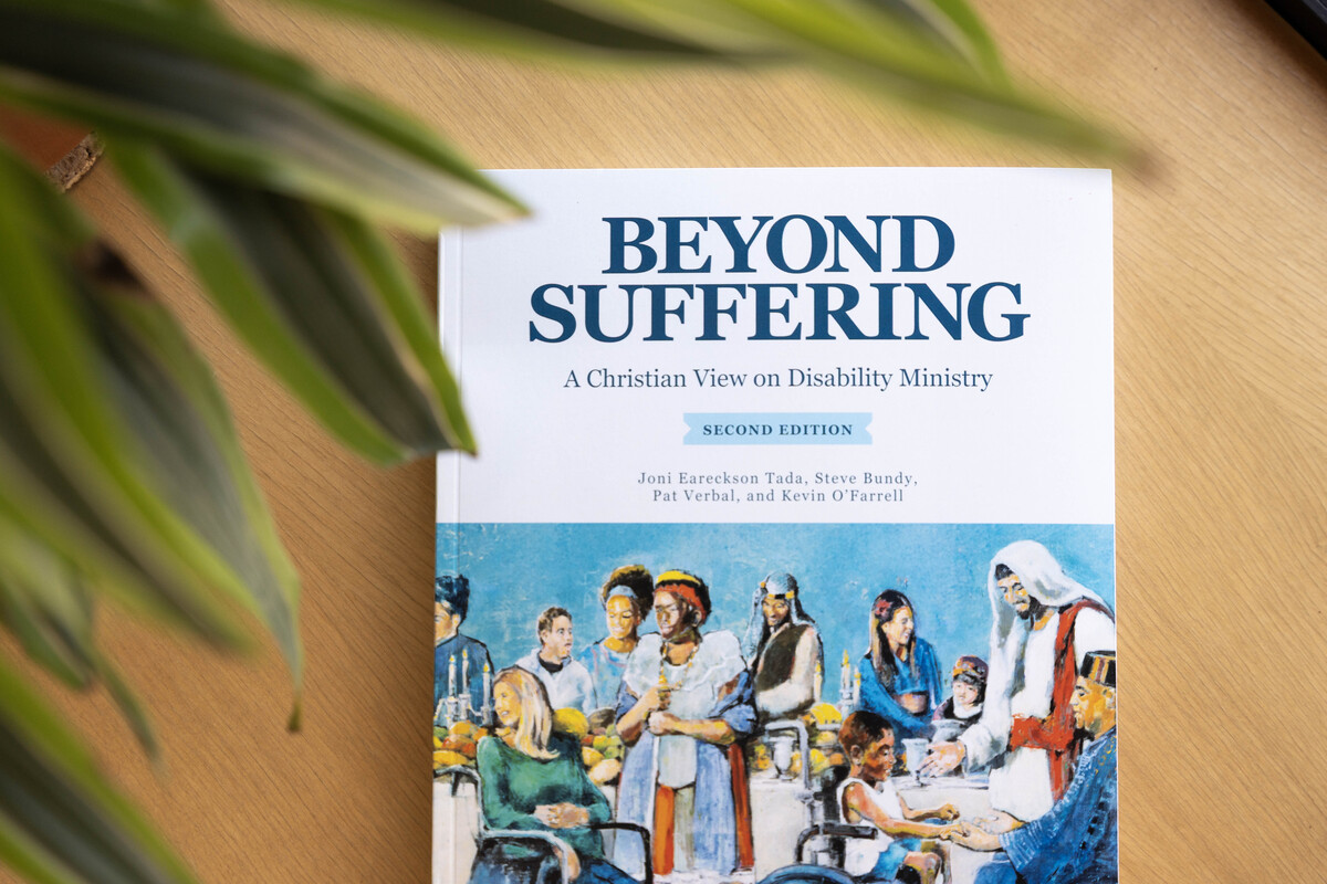 The book cover of Beyond Suffering: A Christian View on Disability Ministry, Second Edition, featuring an artwork of Jesus seated at a table with people with disabilities.