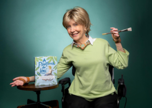Joni holding a paintbrush, next to the book A Paintbrush with Joni