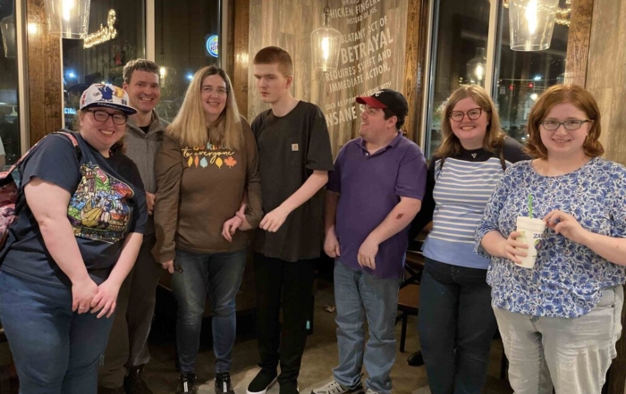 Jennifer and Michael Clayton with their five children, all smiling for the camera inside a restaurant.