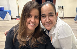 Imelda Cuevas standing next to a woman in a wheelchair, both smiling and posing for the camera.
