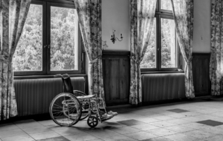 An empty wheelchair by a window