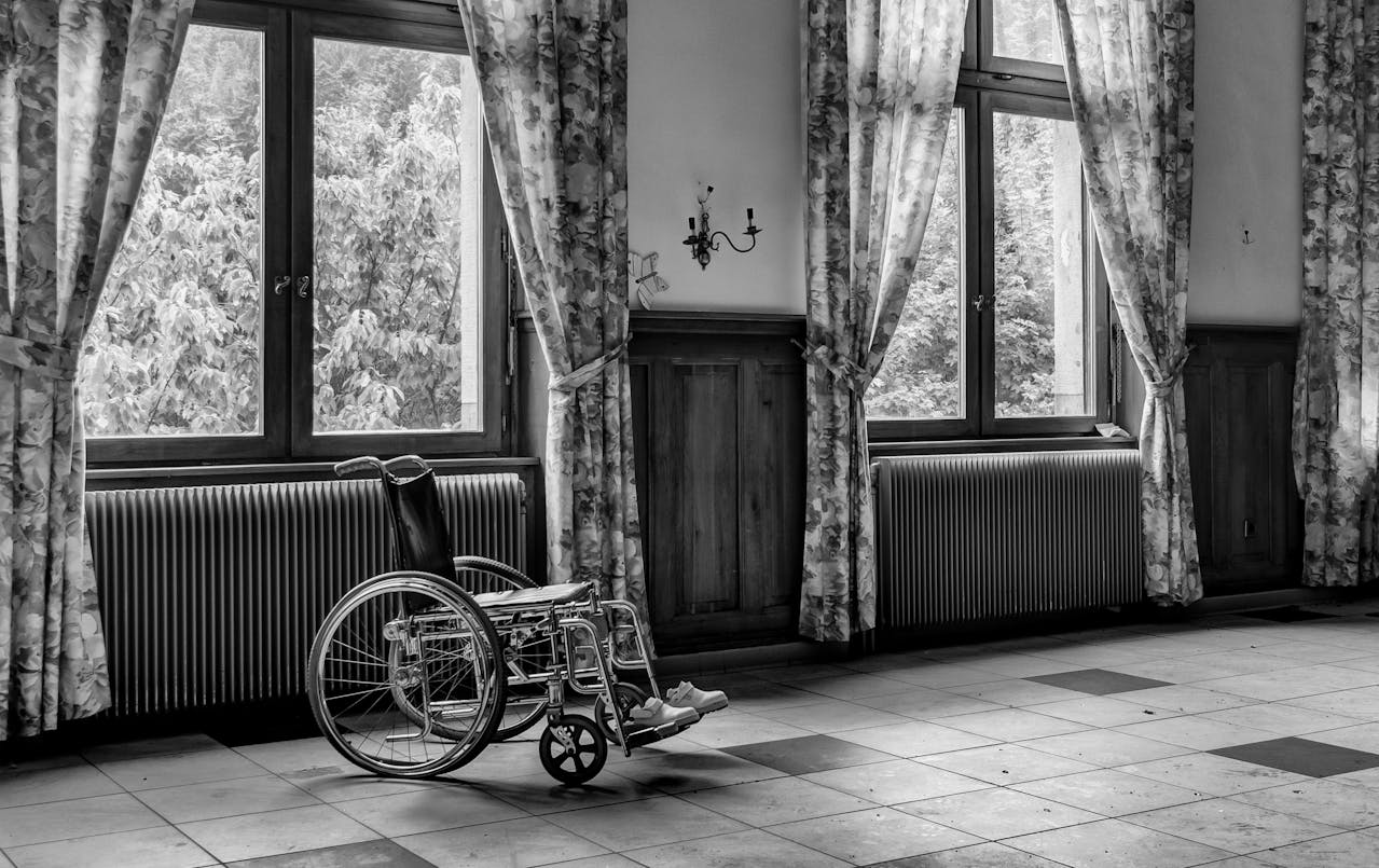 An empty wheelchair by a window