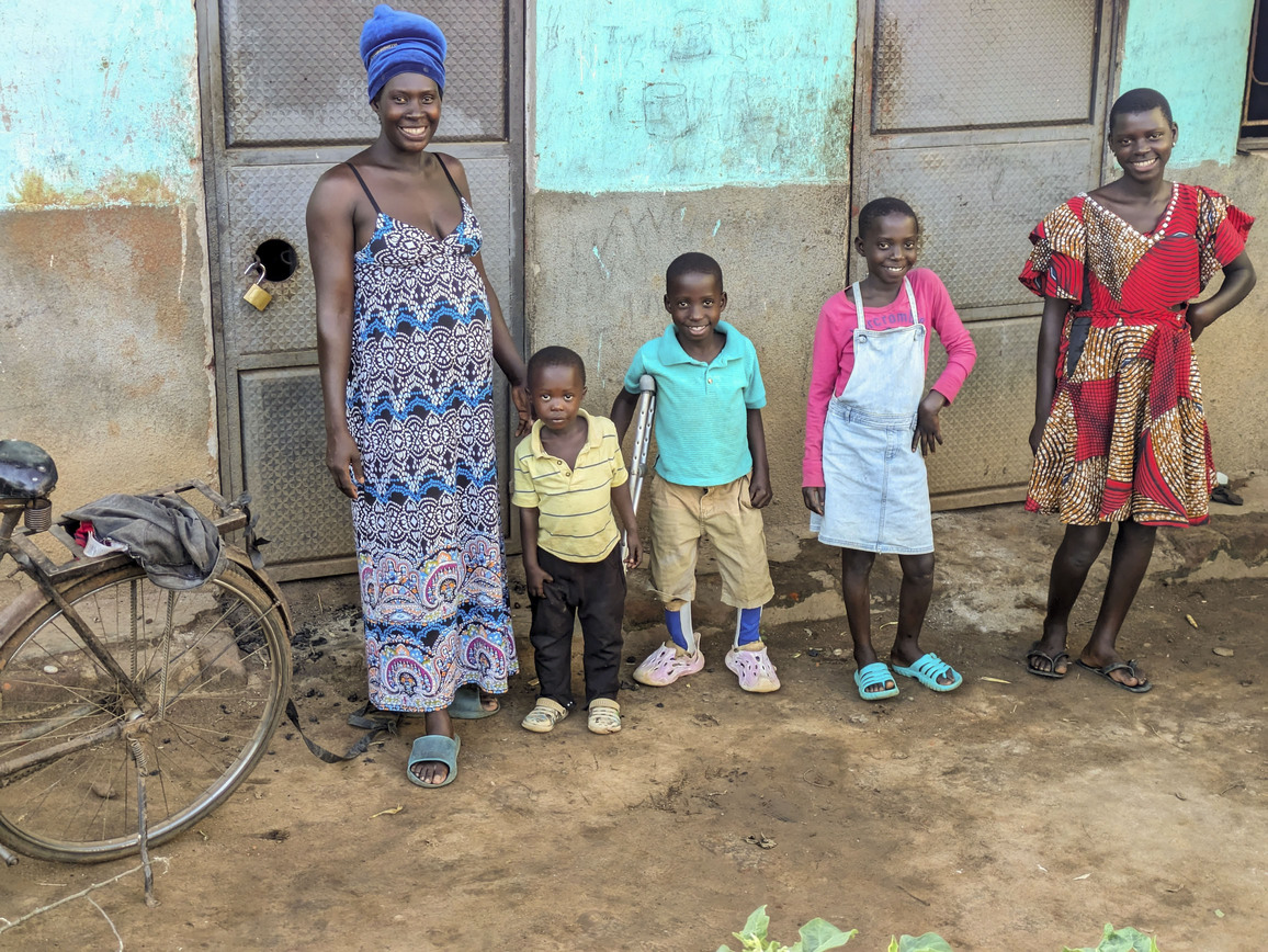 Angello stands with his crutches and leg braces alongside his mom his brother and two young girls.