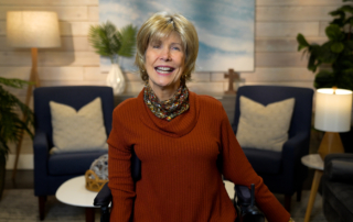 Joni Eareckson Tada smiling for the camera in a cozy living room setup.