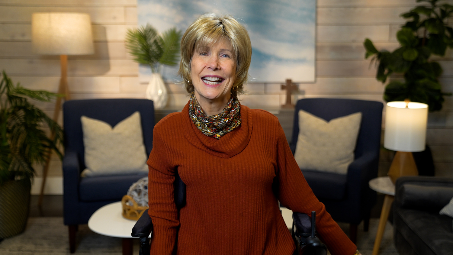 Joni Eareckson Tada smiling for the camera in a cozy living room setup.