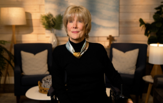 Joni Eareckson Tada smiling for the camera in a cozy living room setup.