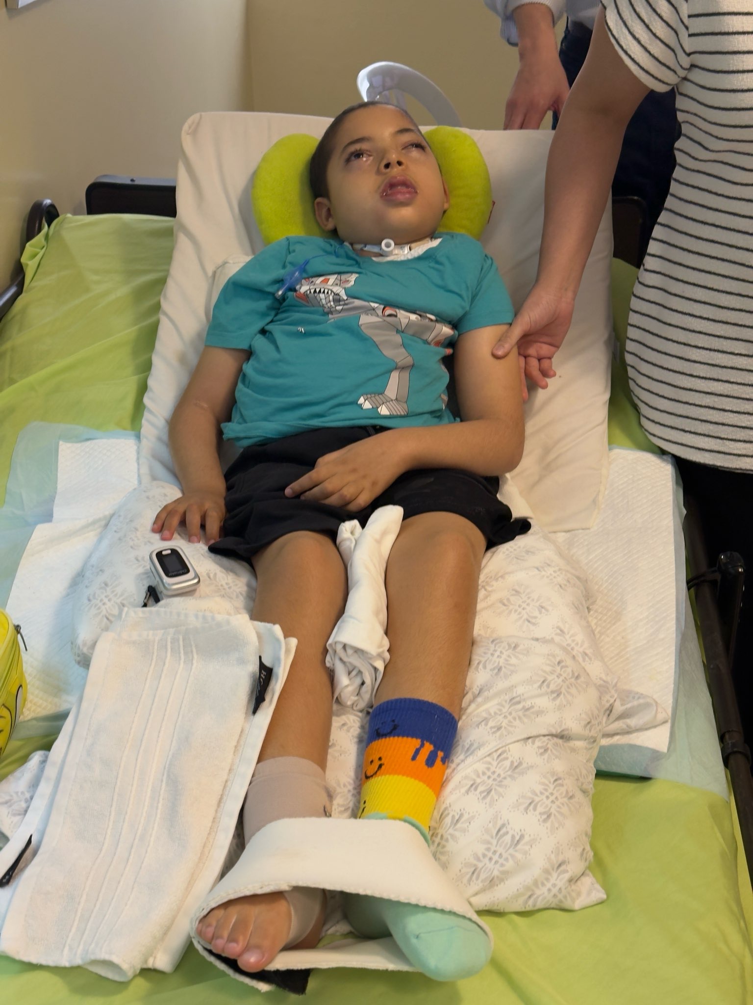Carlito lying on a green bed while being fitted for a wheelchair.