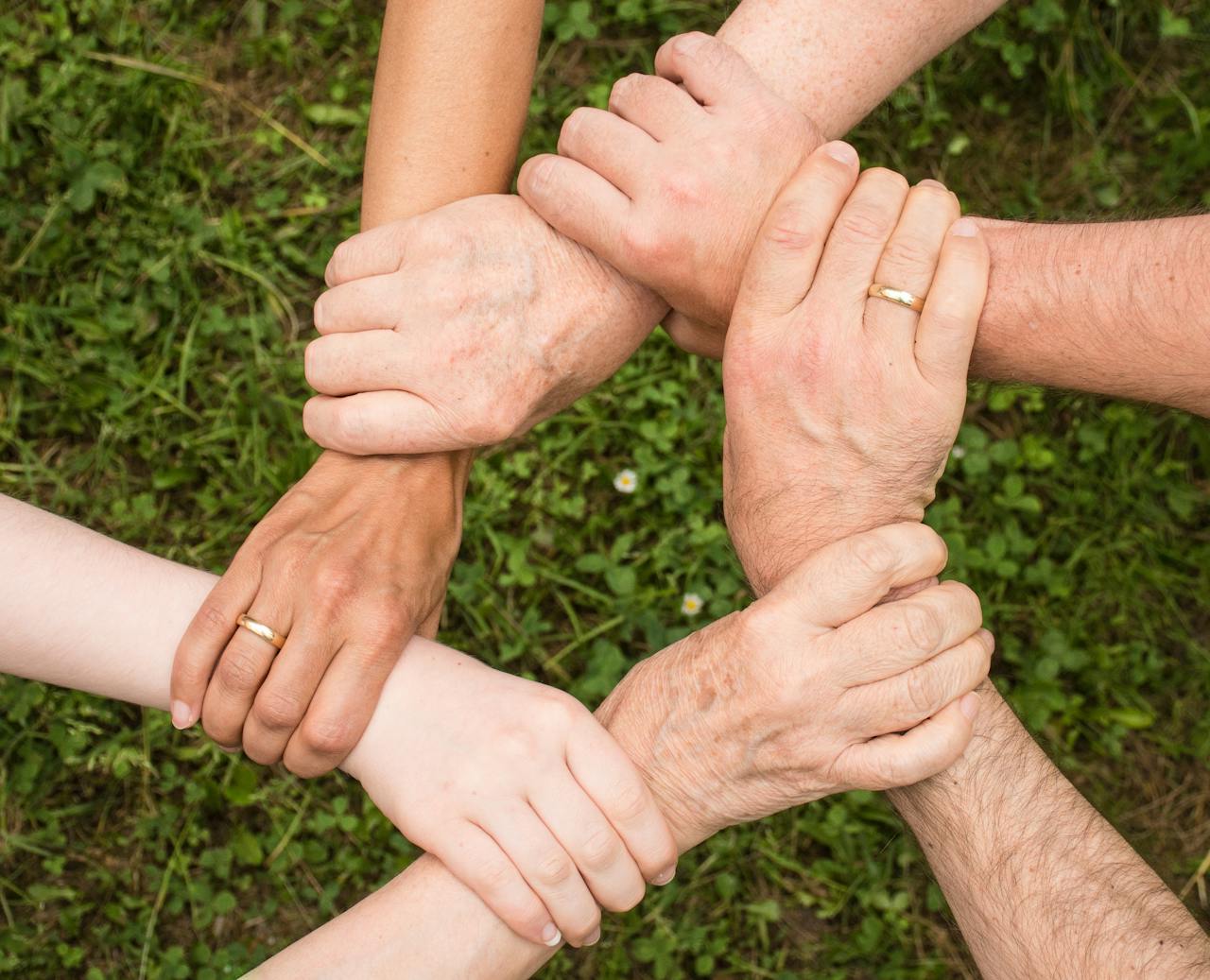 A group of people linking arms in a circular formation.