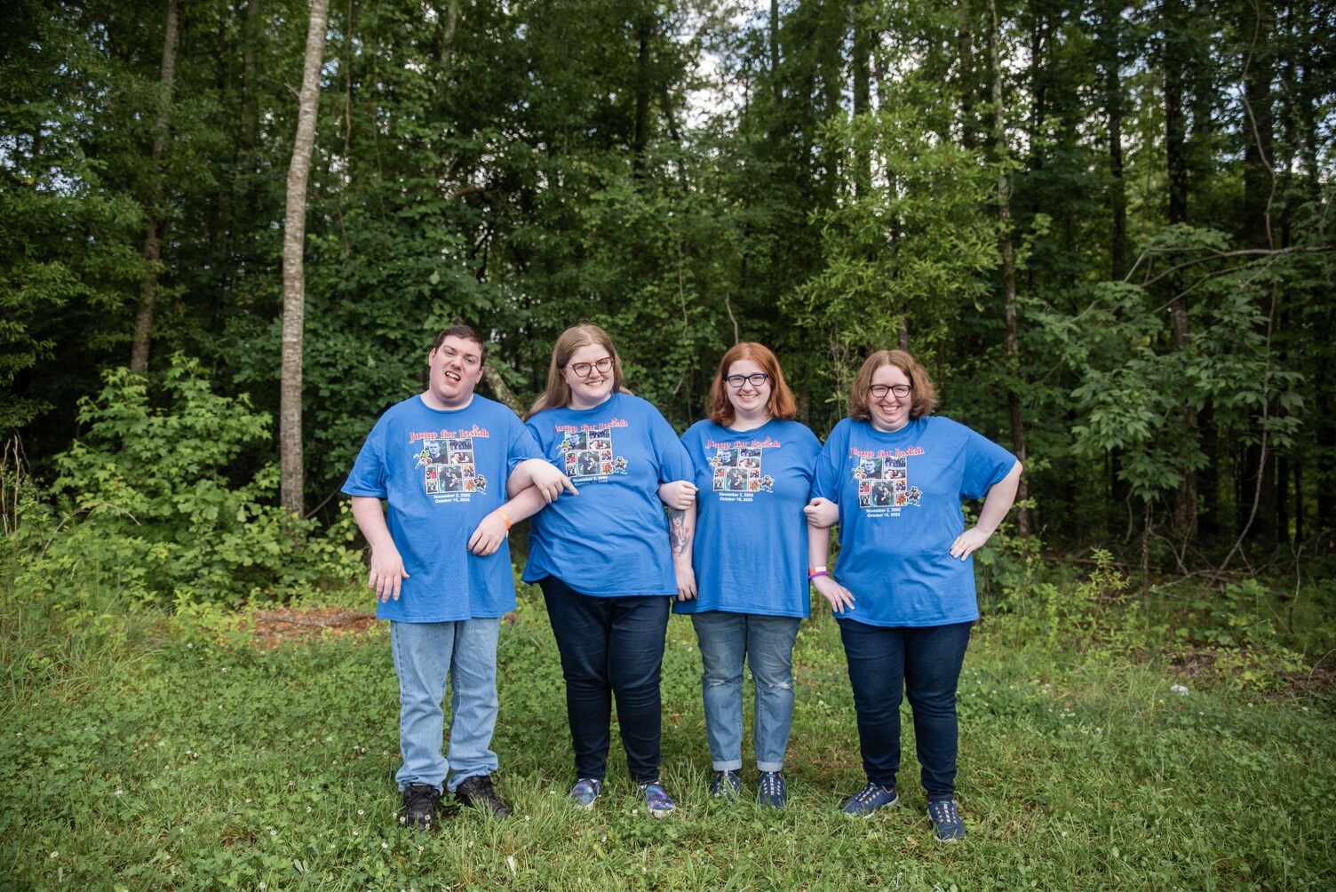 The Clayton siblings, three daughters and one son, standing side by side outdoors, smiling and posing together for the camera, showing a close family bond.