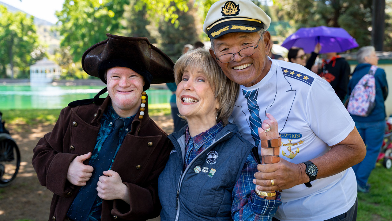 Joni and Ken Tada with a boy with down syndrome all smiling and posing for the camera.