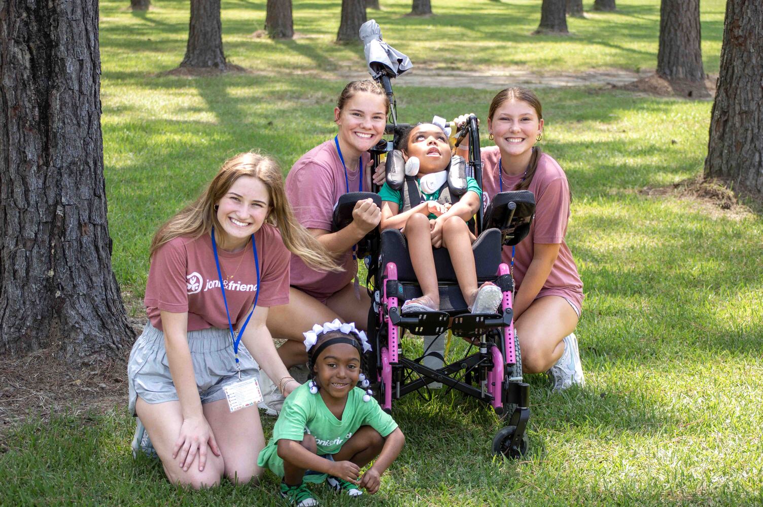 Taliyah with three volunteers and a young girl in a wheelchair, all smiling at the camera.