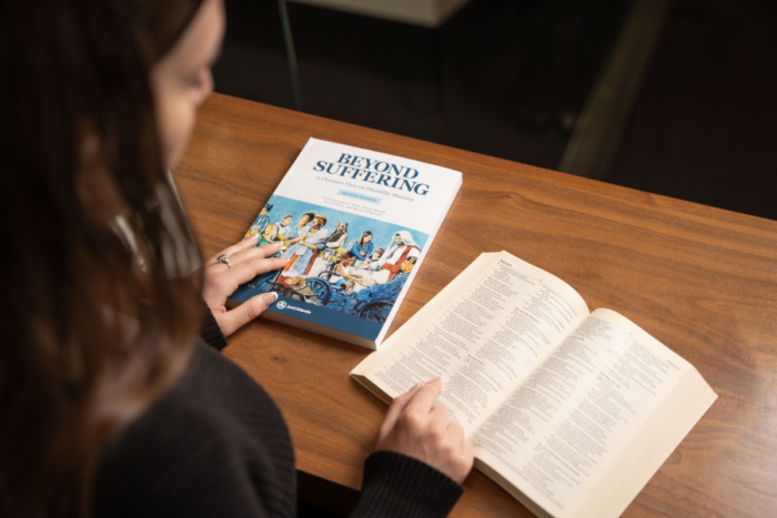 A student with the Beyond Suffering book and a Bible