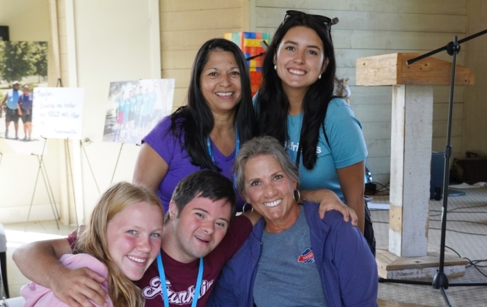 Maria Lee standing with staff and participants at a Joni and Friends event, smiling and posing for a group photo.