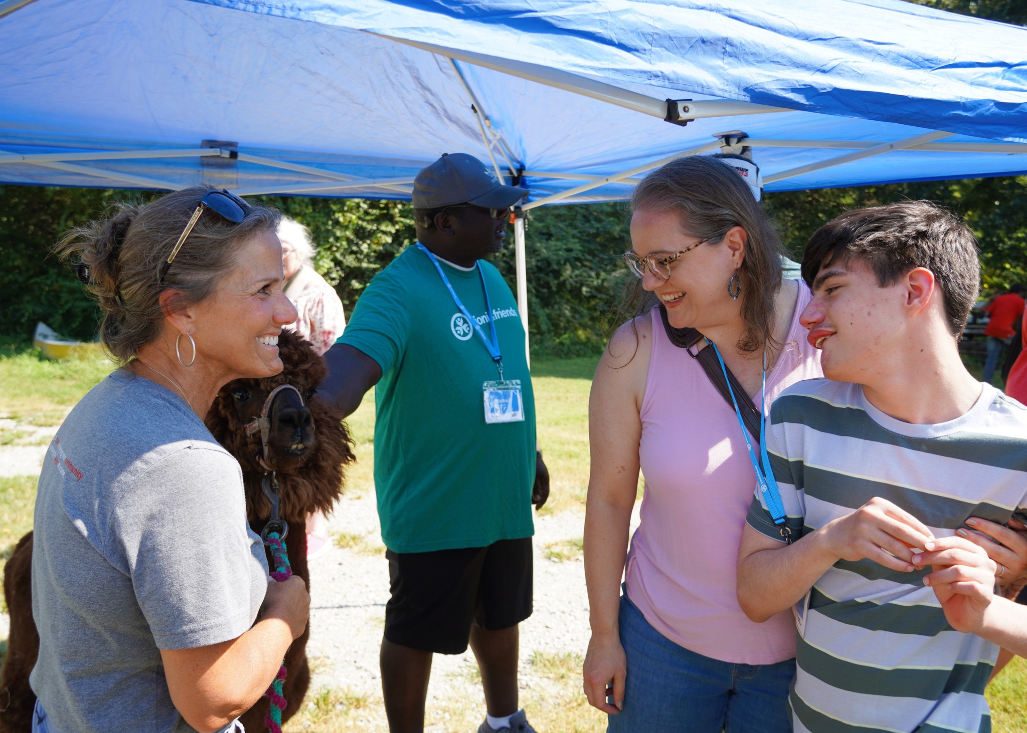 Maria Lee smiling with a participant and a staff member as they look at an animal at the Joni and Friends Family Retreat.