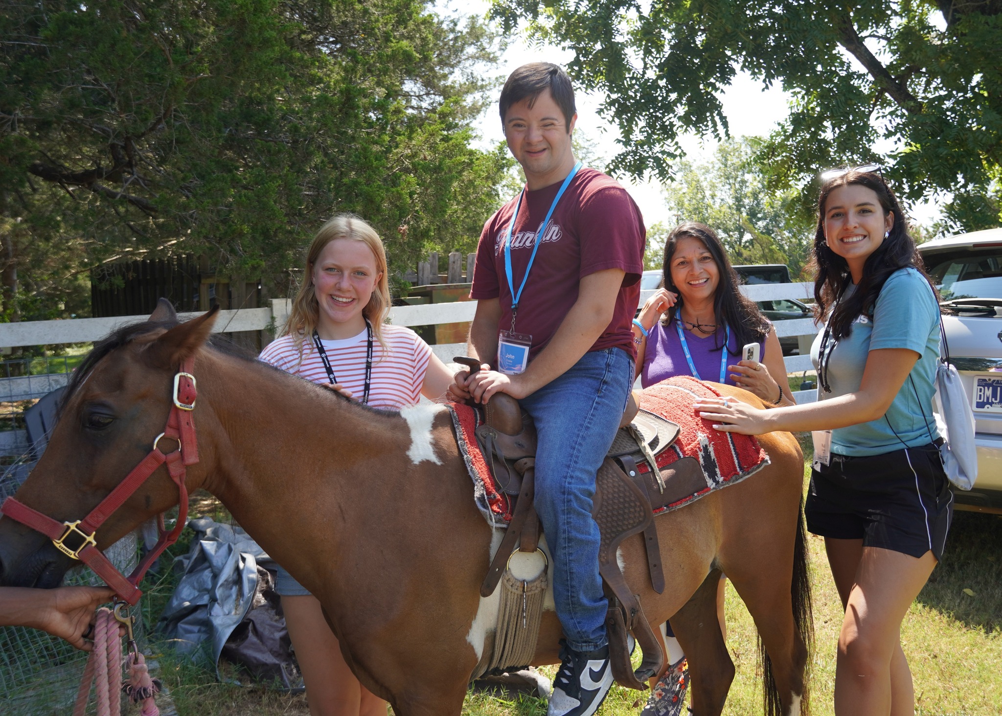 Staff members assisting a participant who is riding a horse at the Joni and Friends Family Retreat.