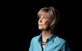 Side view of Joni Eareckson Tada looking upward against a pitch-black background.