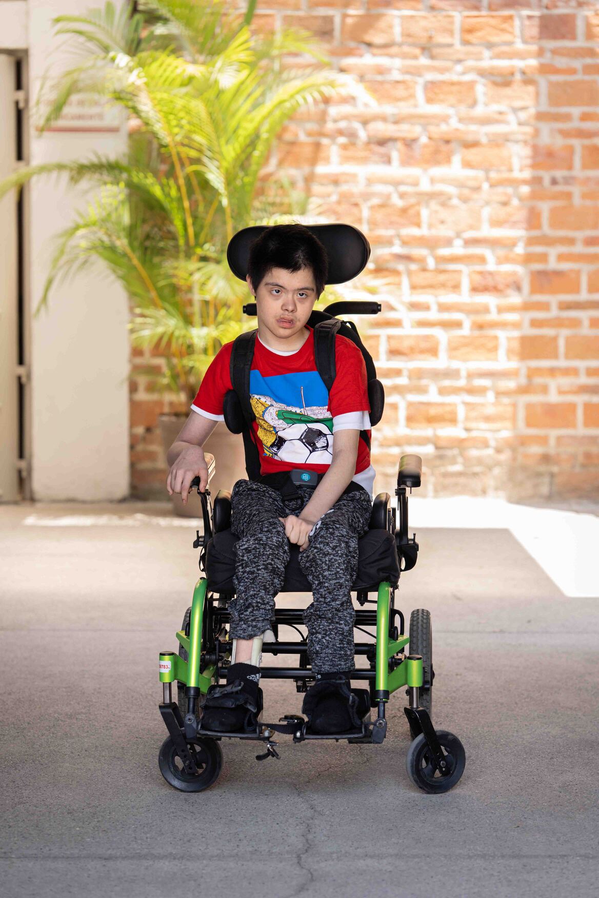 Full-body shot of Donovan sitting in his new wheelchair.