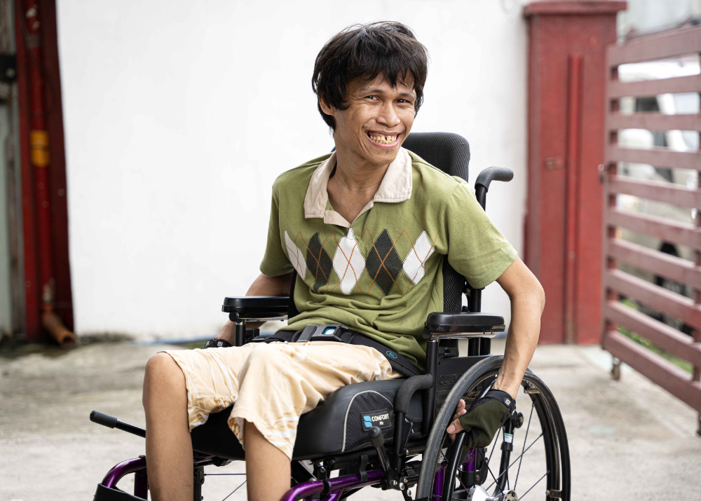 A man smiles in his new wheelchair