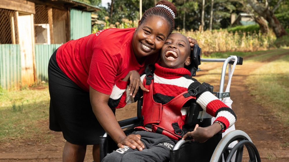 A mother and child pose for a photo at a Wheels for the World® Outreach