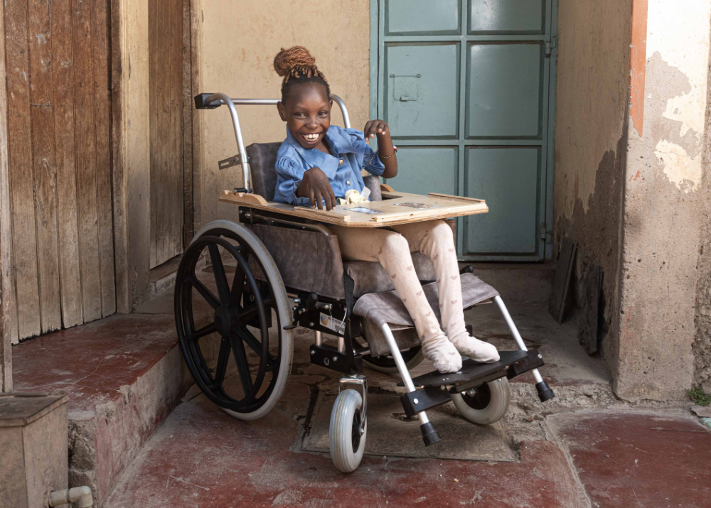 A girl smiles in her new wheelchair