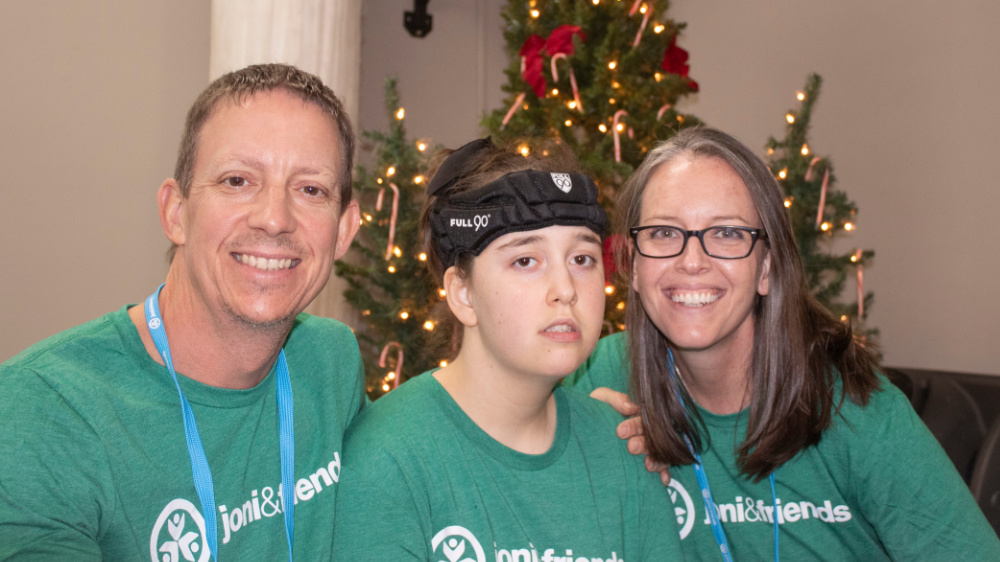 Joni and Friends events A family poses for a photo in front of a Christmas tree