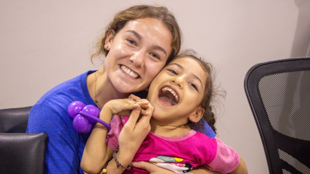 An intern and child pose for a photo
