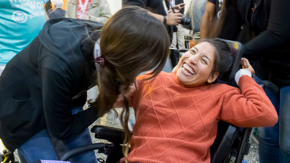 A woman smiles in her new wheelchair