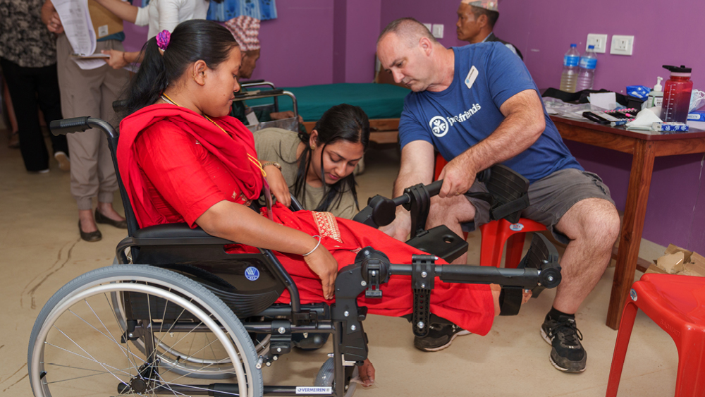 A woman gets fitted for a wheelchair