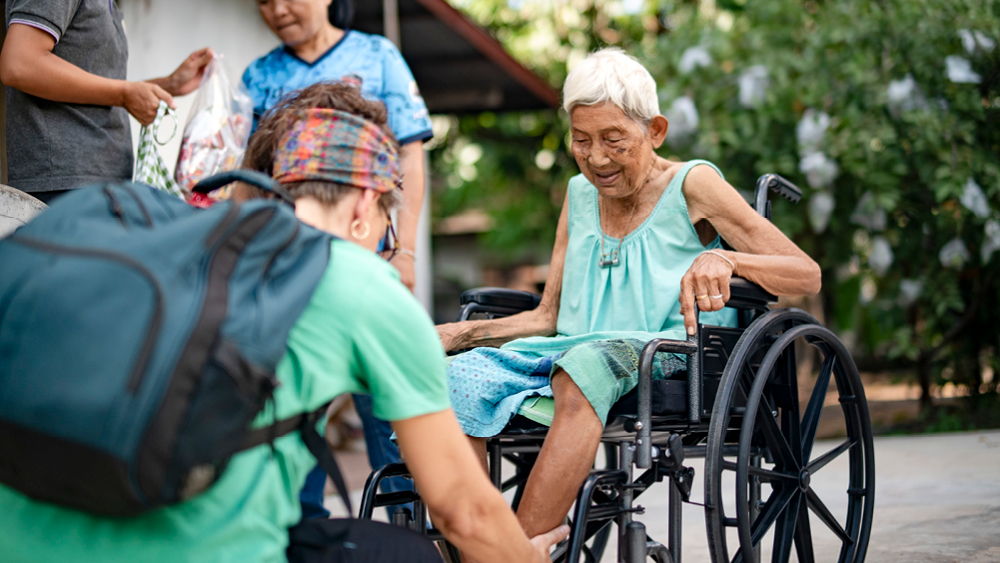 An elderly woman gets fitted for a wheelchair