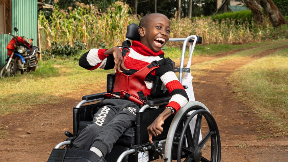 A child smiles in his new wheelchair