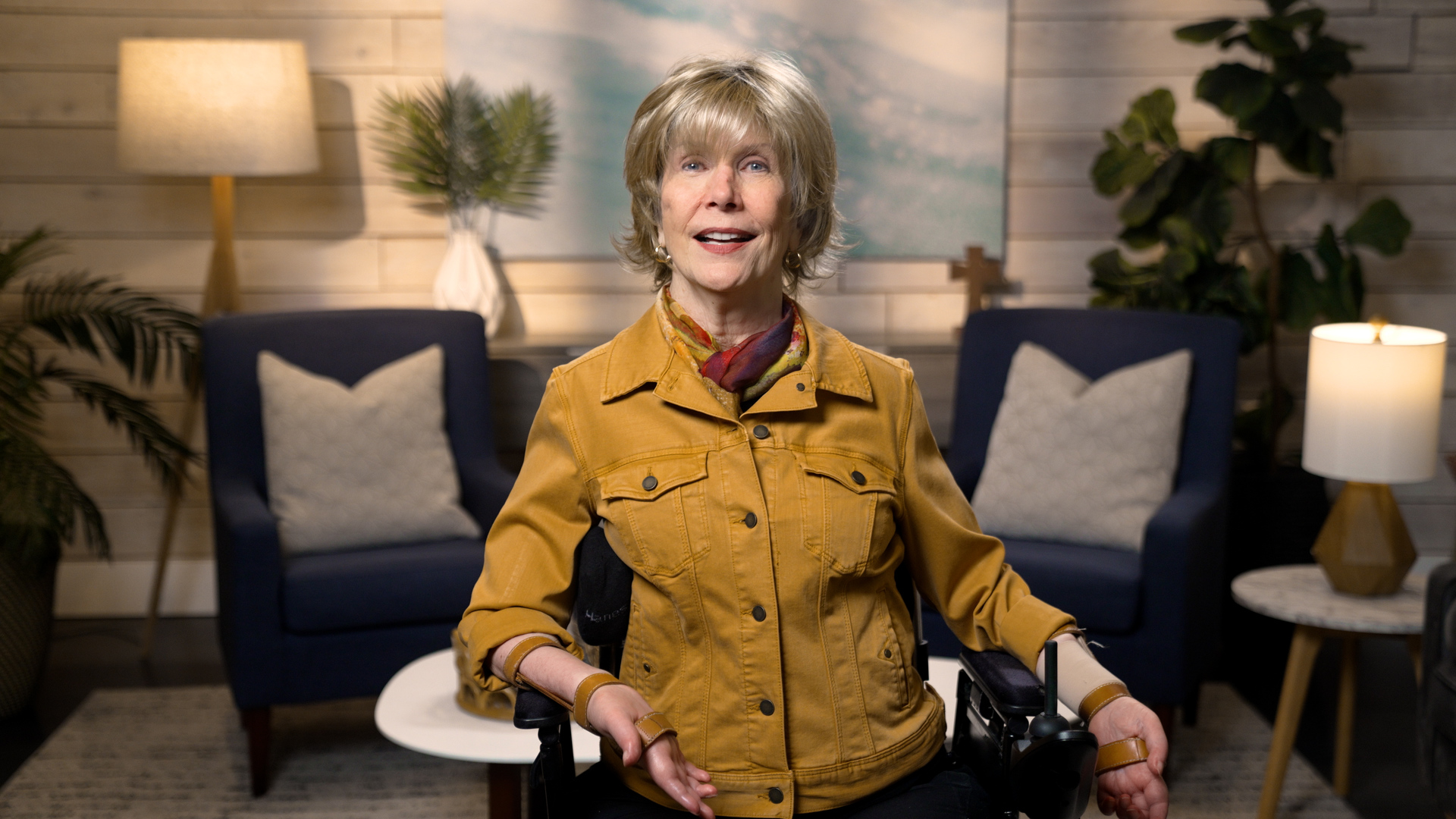 Joni Eareckson Tada smiling for the camera in a cozy living room setup.