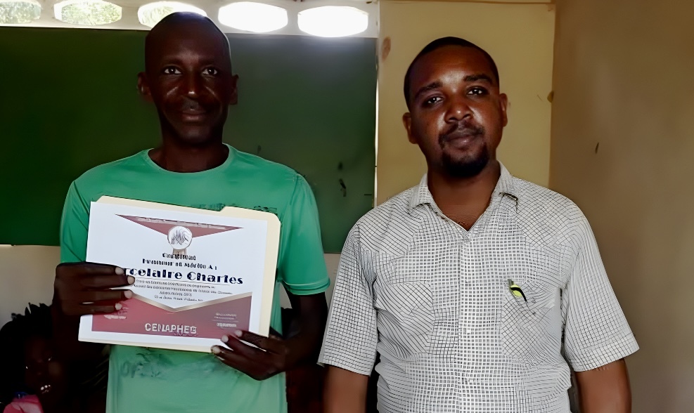Alfreno next to a Motorbike taxi driver. Both are smiling for the camera.